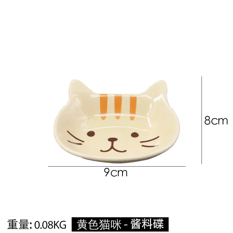 A light beige ceramic cat-shaped sauce dish with orange stripes, measuring 9cm by 8cm.