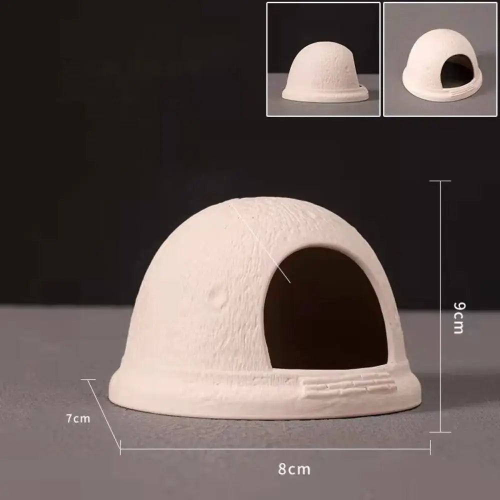 A beige ceramic aquarium shrimp hideaway cave with an arched entrance and a flat base.