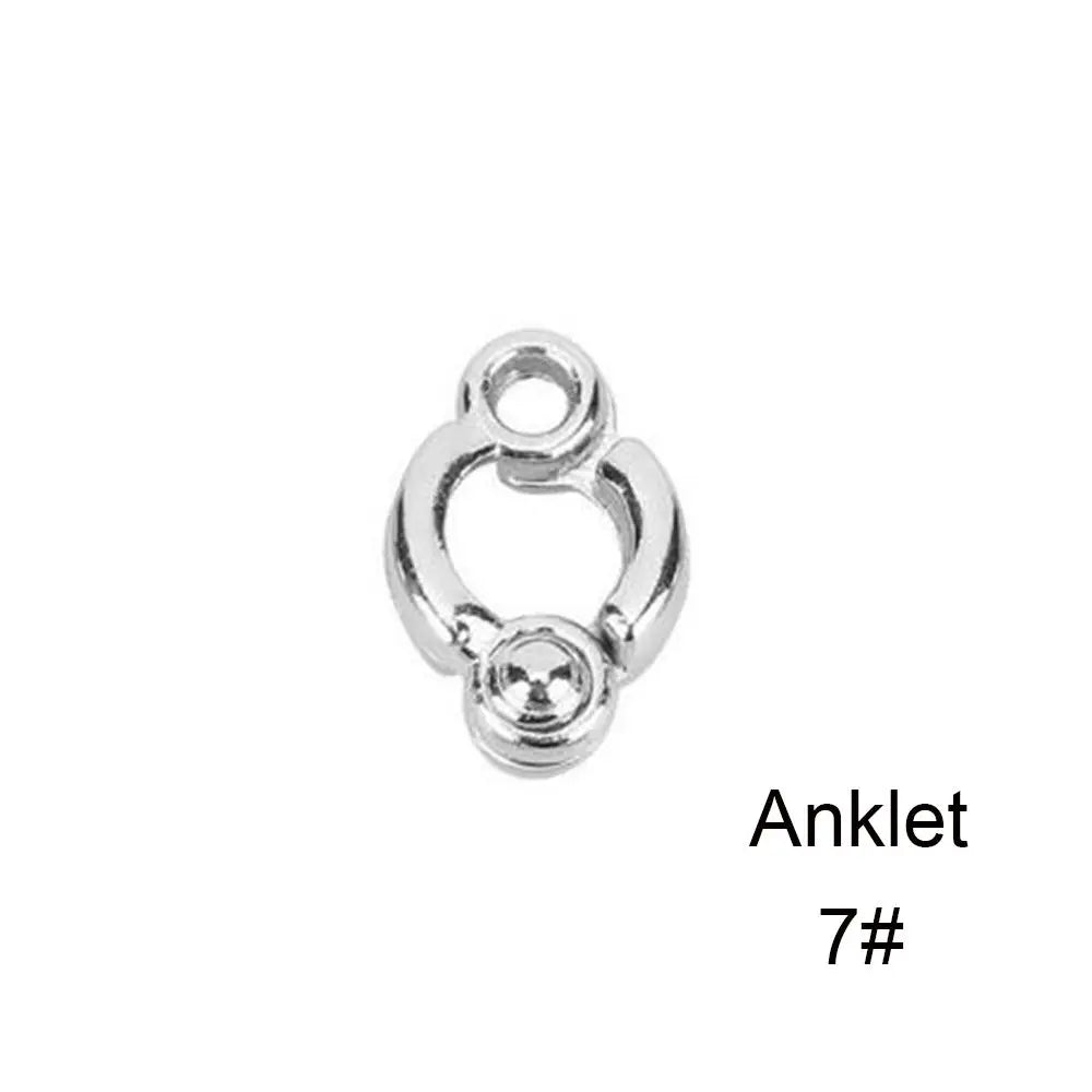 Silver ankle bracelet with a decorative loop and a small round charm.