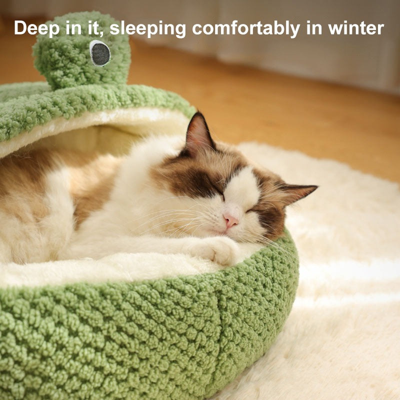 Un gato duerme cómodamente dentro de un nido de peluche verde diseñado para el confort invernal.