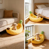 Un lit pour chien en forme de banane jaune avec des accents verts, montré pour un chien dans une pièce lumineuse.