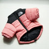 A pink and black quilted winter coat for a dog, shown flat against a white background.