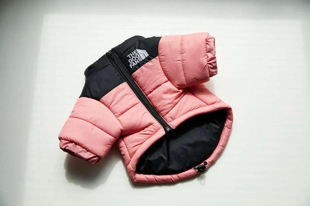 A pink and black quilted winter coat for a dog, shown flat against a white background.