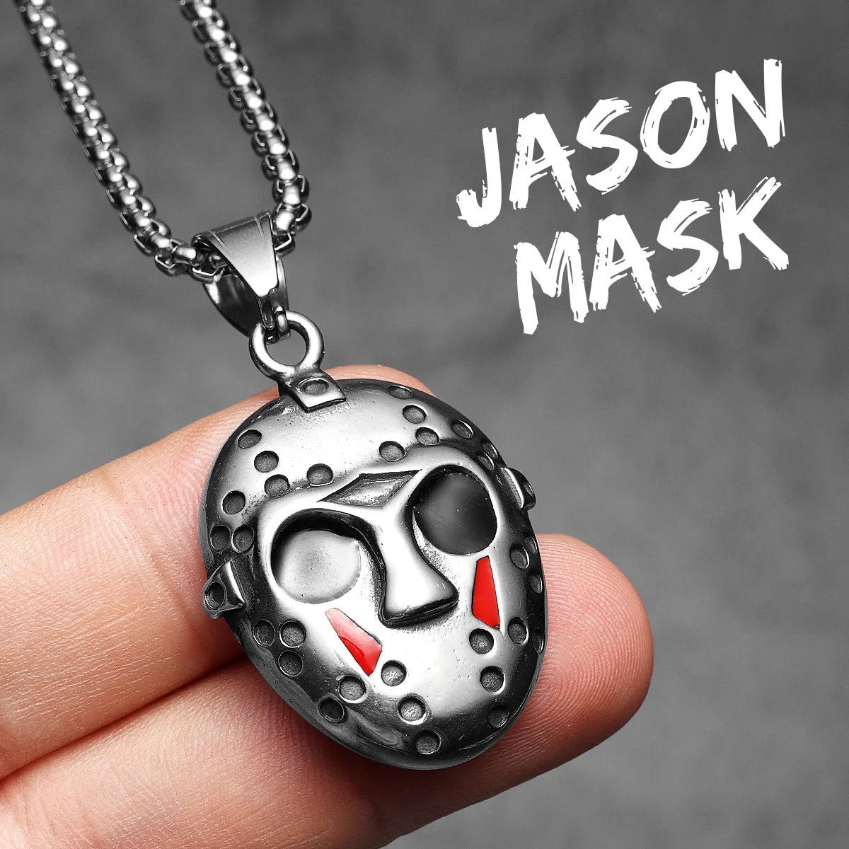 A silver stainless steel pendant necklace featuring a Jason Mask skull design is held in a hand.