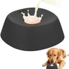 A dark gray ergonomic slow feeder dog bowl with a white food being dispensed onto the surface.