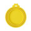 Yellow reusable silicone pet food can lid with a spoon.
