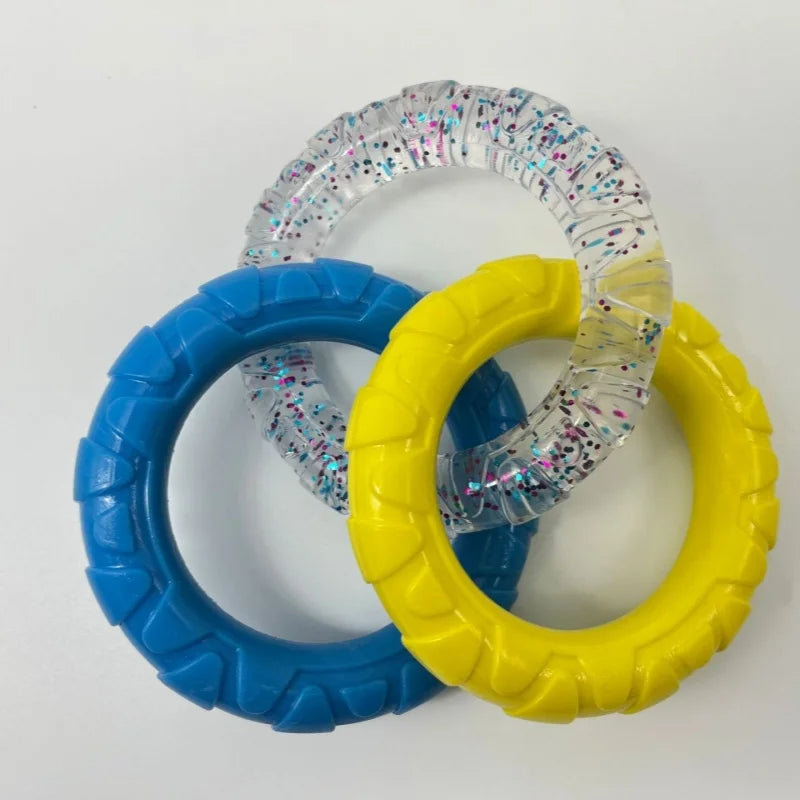 Three colorful TPR pull ring dog chew toys in blue, yellow, and clear with glitter.