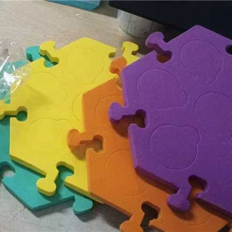 A set of colorful puzzle mats made of interlocking foam pieces in yellow, orange, and purple.