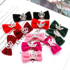 A collection of glitter dog bow hair clips in various shades of pink, red, and green with silver crowns.