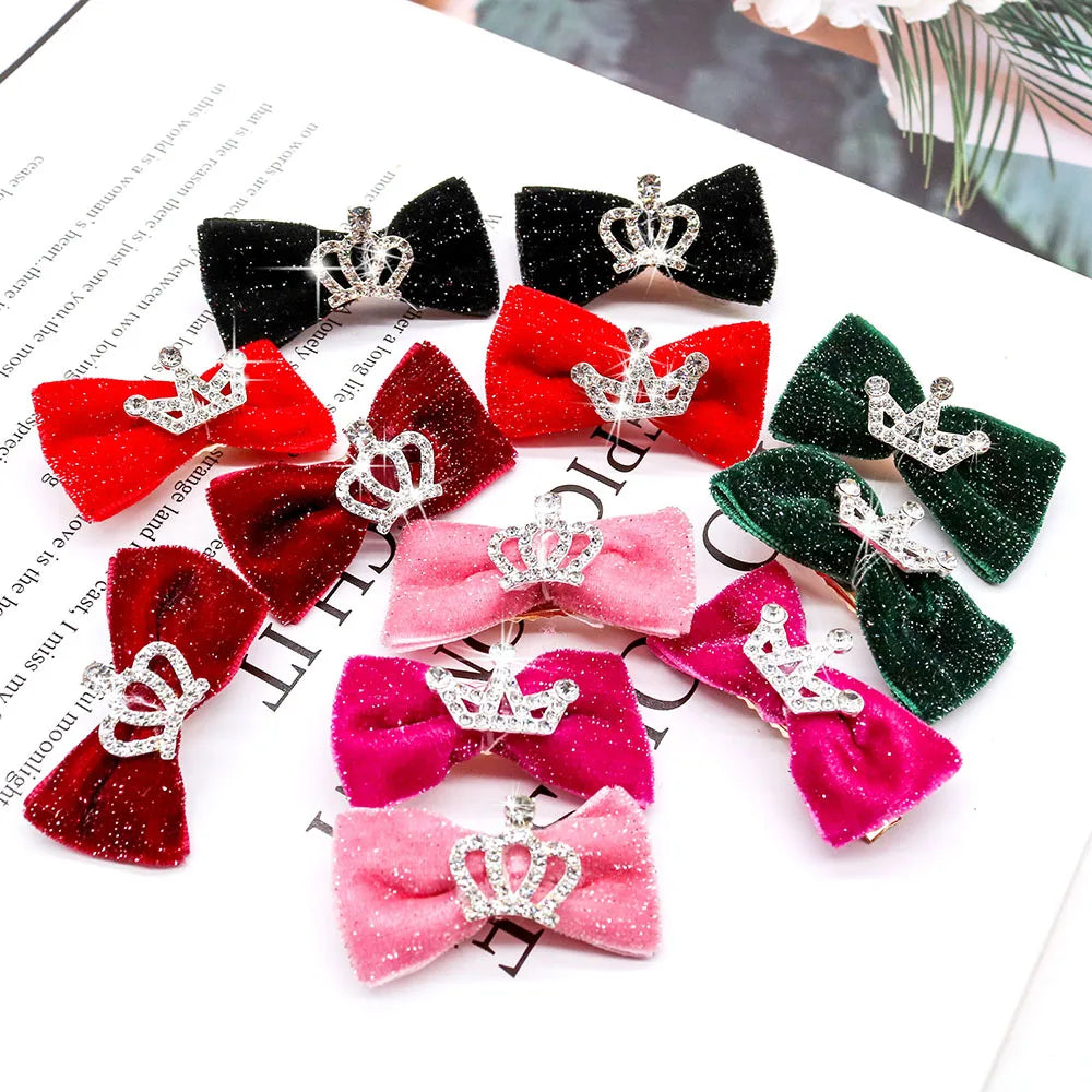 A collection of glitter dog bow hair clips in various shades of pink, red, and green with silver crowns.