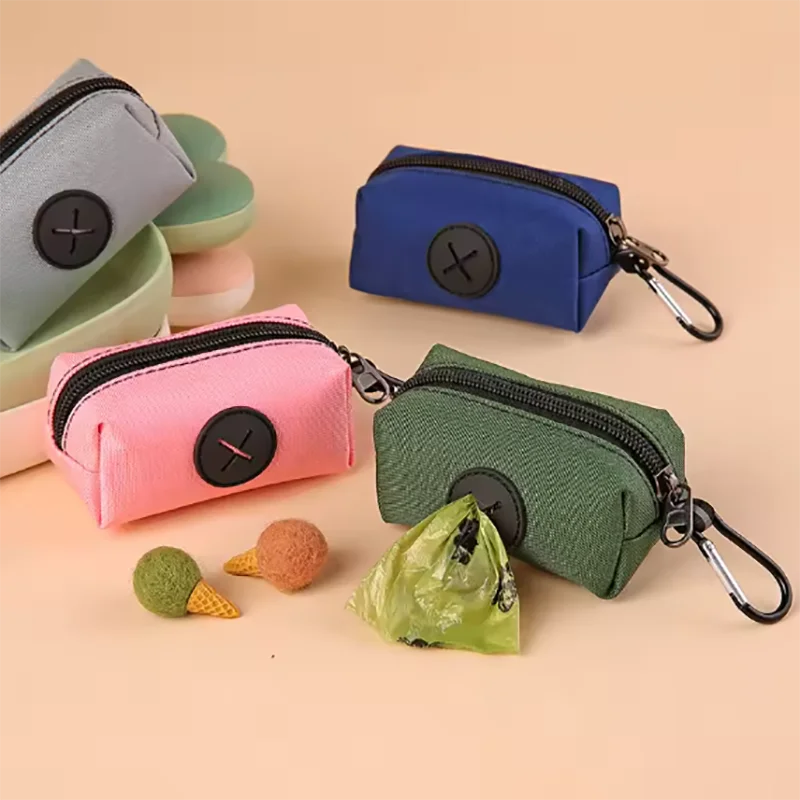 A collection of colorful fabric pouches and a green carabiner dog poop bag dispenser on a beige background.