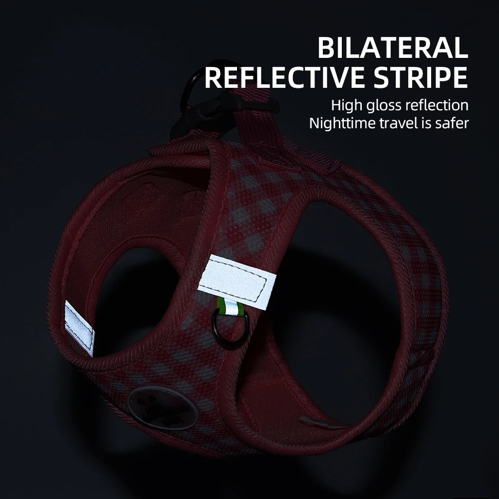 A maroon plaid pet harness with high gloss reflective stripes shown against a dark background.