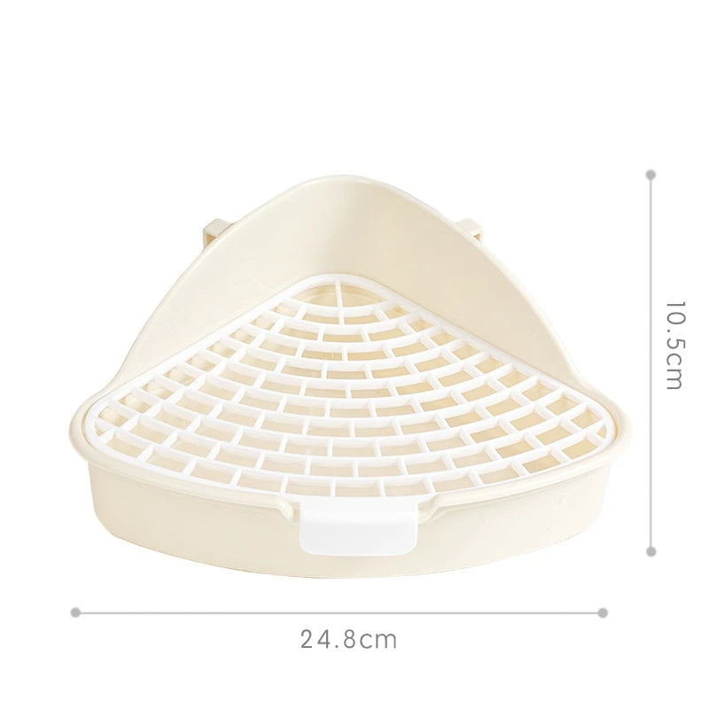 A beige corner litter box with a removable plastic grate for small pets.