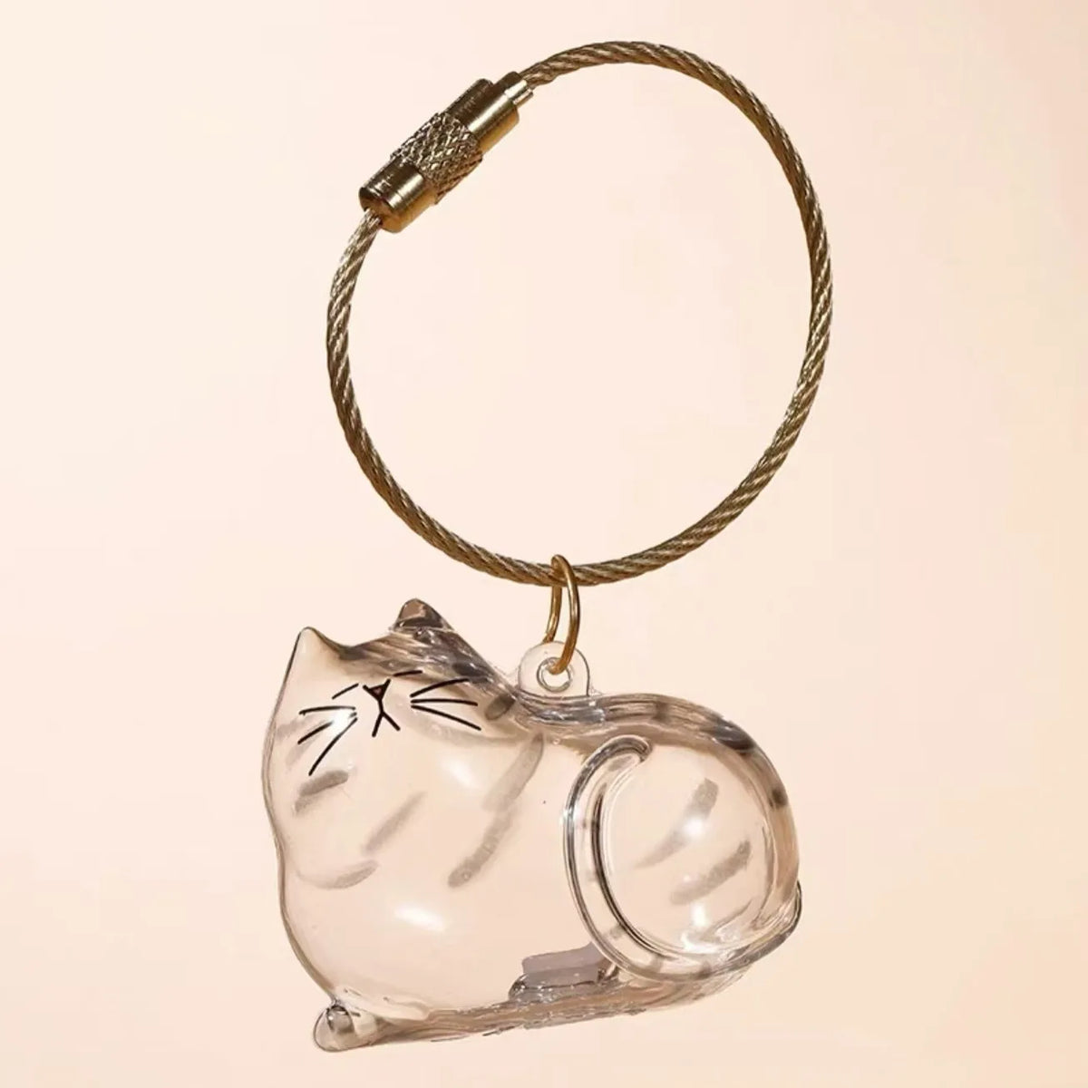 A clear glass cat charm keychain with a gold-colored cord and a metal clasp.