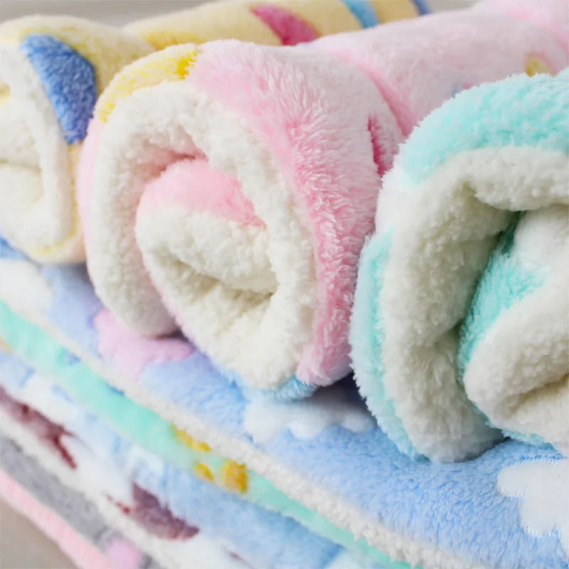 Rolled plush fleece blanket in pink, white, and light blue colors for pets