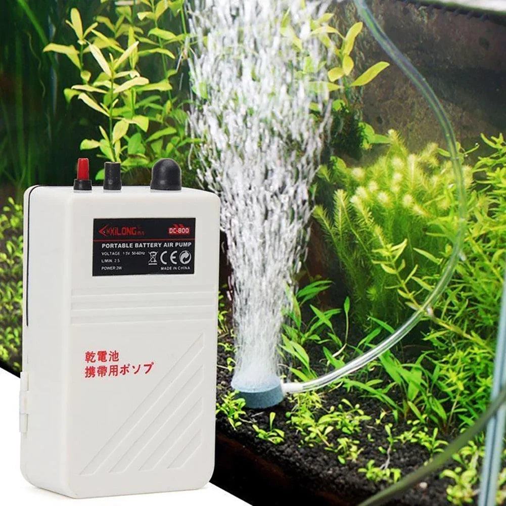 A white portable battery air pump is shown operating in an aquarium, creating a stream of water.