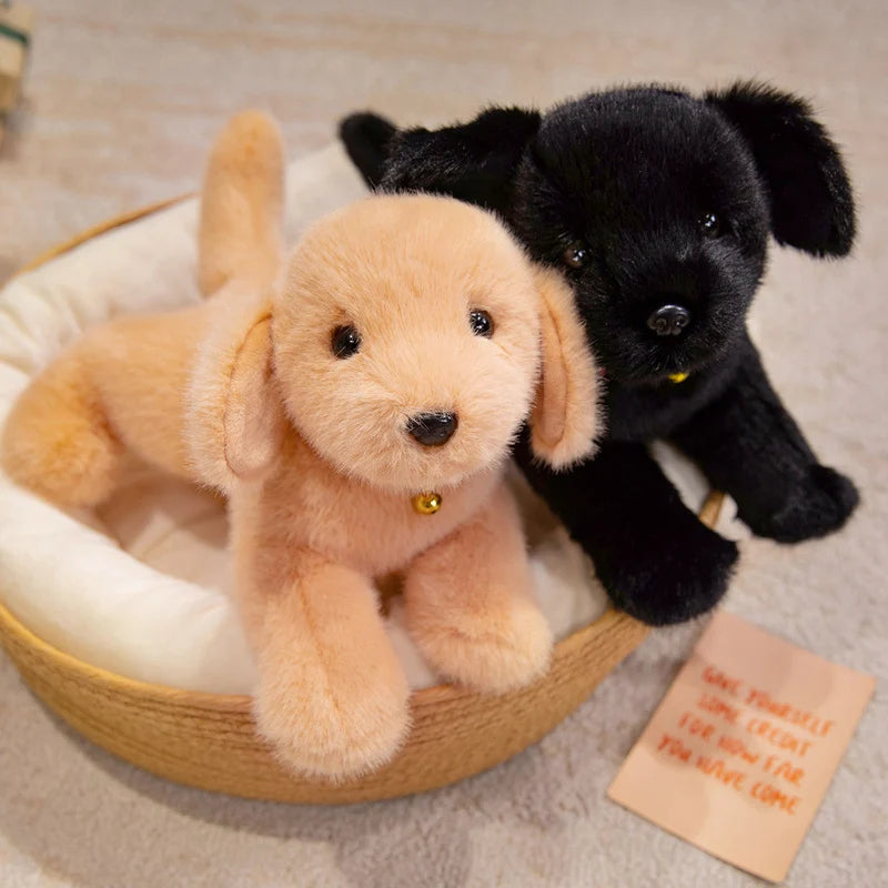 A fluffy golden Labrador plush toy next to a black Labrador plush toy, resting in a woven bowl.