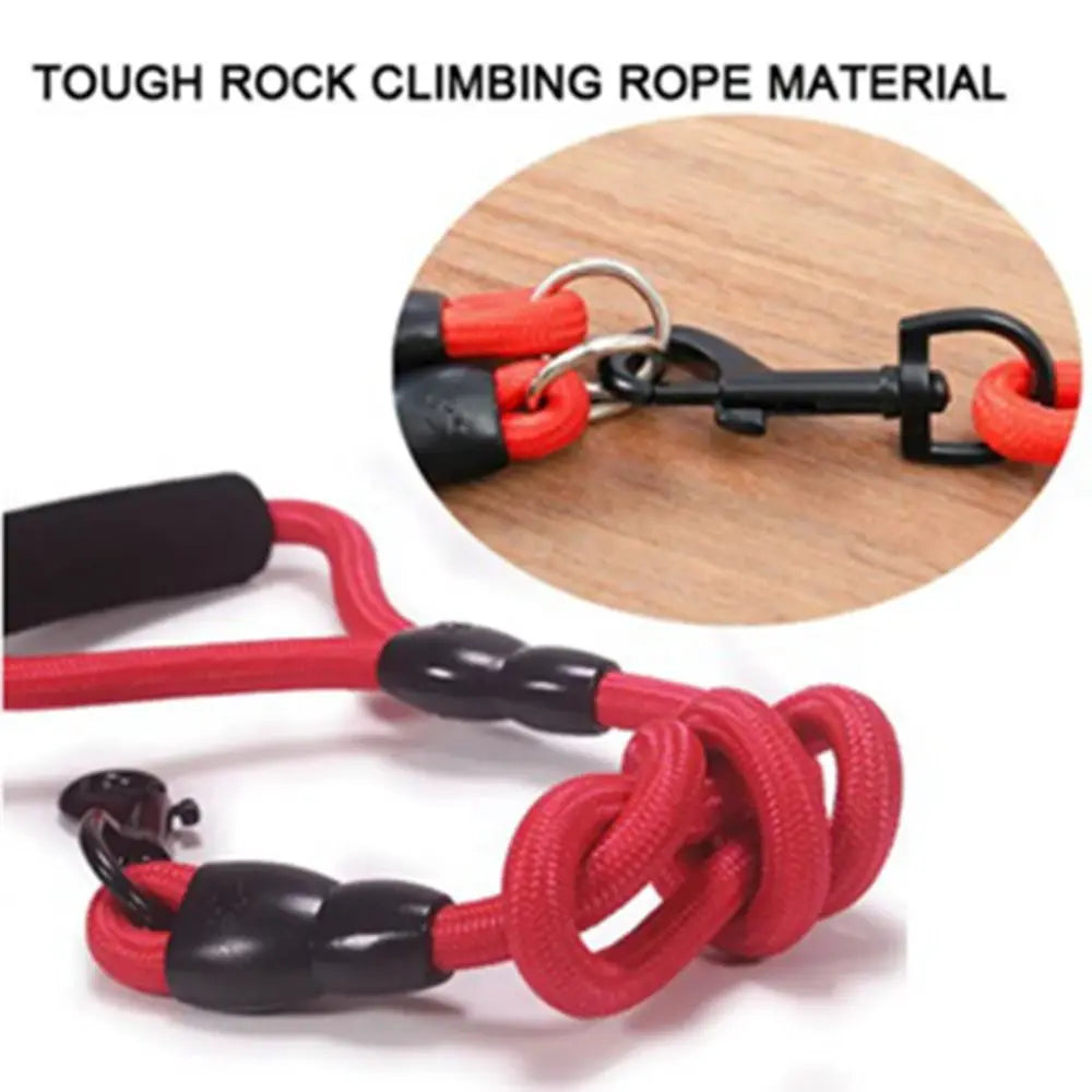 A close-up of a red and black rope material dual dog leash coupler with metal clasps.