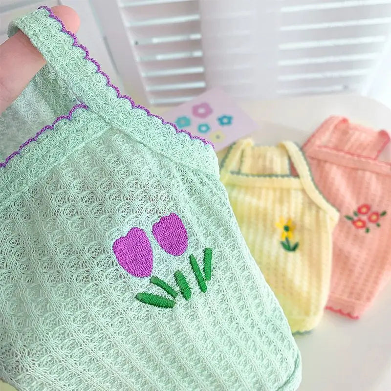 Light green knitted vest for a dog featuring purple and green floral embroidery