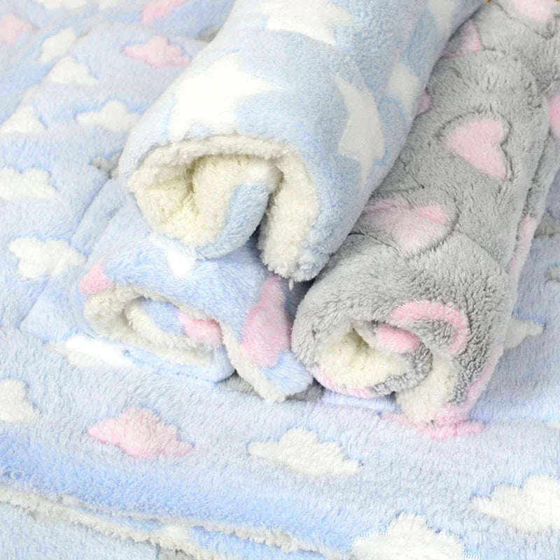 Light blue plush fleece blanket with pink cloud patterns rolled up.
