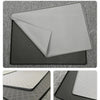 A close-up photo showing a gray silicone pet feeding mat layered over a black mat on a textured surface.
