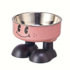 A pink and silver elevated stainless steel pet feeder with a smiling face design.