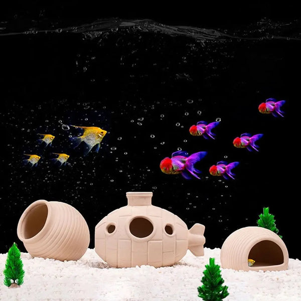 A ceramic aquarium shrimp hideaway cave is shown resting on white sand with green foliage.