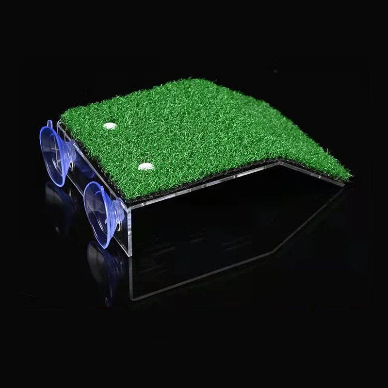 A clear acrylic platform with a green grass ramp and suction cups is shown against a black background.
