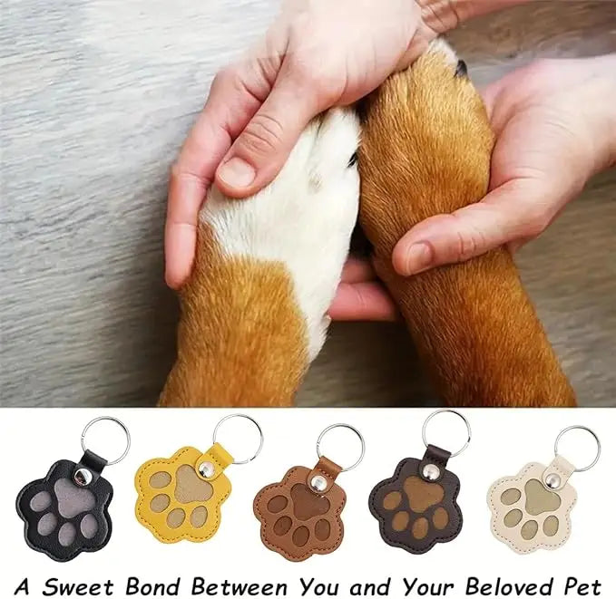 A close-up of a hand gently holding a leather pet fur keepsake keychain charm with various colors and textures.