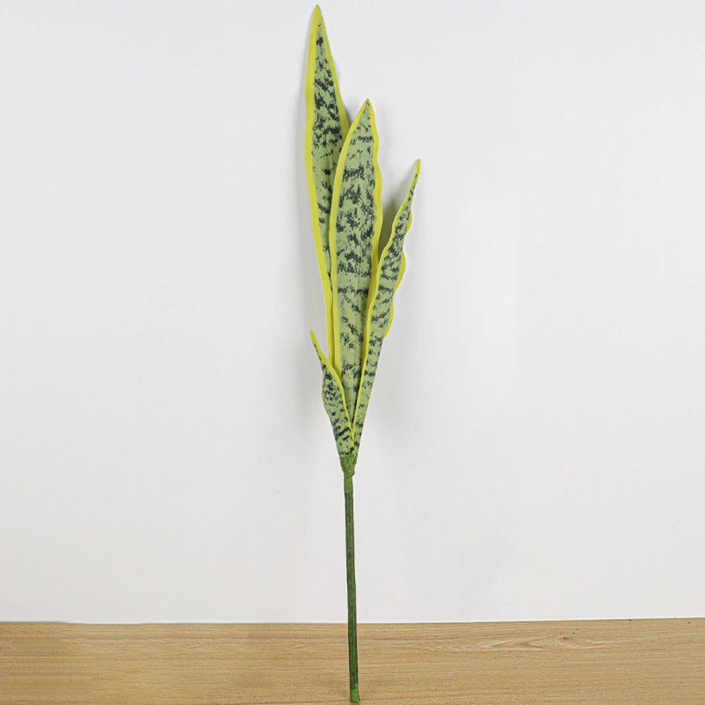 A tall artificial snake plant with long, narrow leaves in shades of green and yellow against a white background.