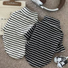 A black and white striped thermal sweater for a small dog lying on a beige surface.