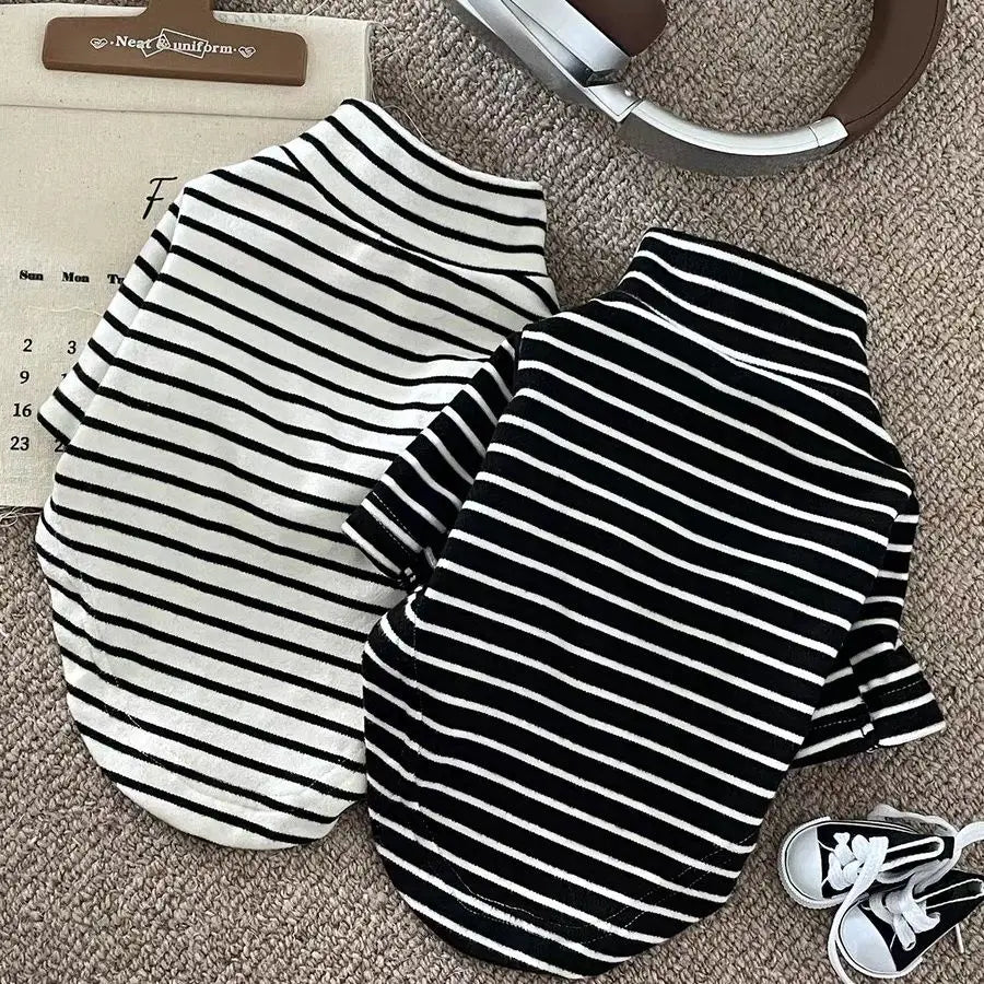 A black and white striped thermal sweater for a small dog lying on a beige surface.