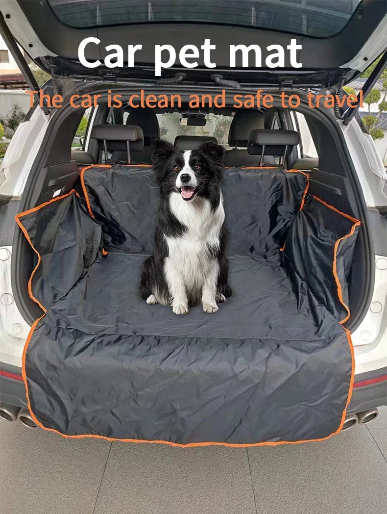 A black and white dog is sitting on a dark waterproof car pet mat inside the open cargo area of a vehicle.