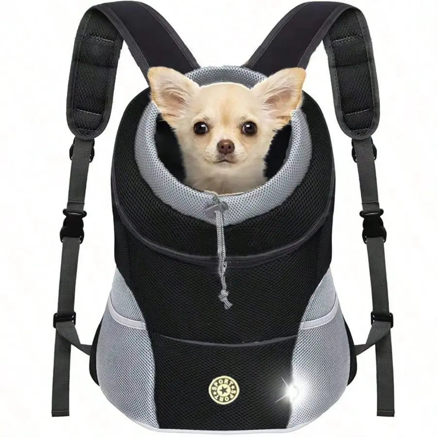 A black ventilated pet carrier backpack with a light-colored dog peering out of the opening.