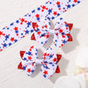 A pair of white and red star ribbon hair bows with clips on a white background.