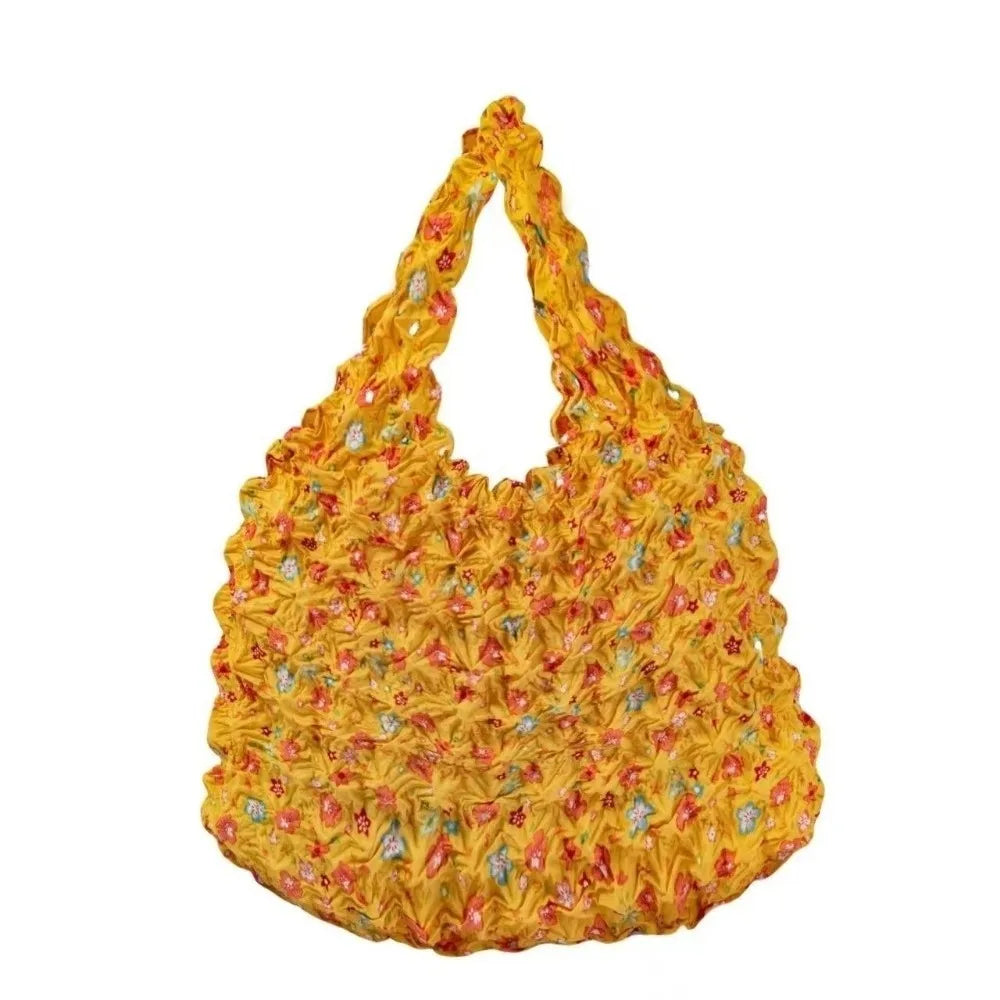 A yellow floral foldable shopping tote bag with a textured pattern.