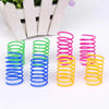 A collection of colorful spring toys in various sizes and colors, including green, blue, pink, and yellow.