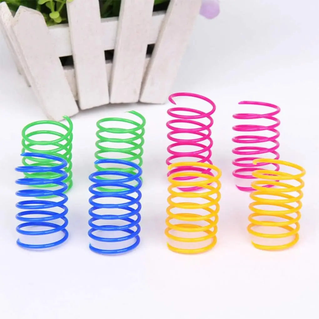 A collection of colorful spring toys in various sizes and colors, including green, blue, pink, and yellow.