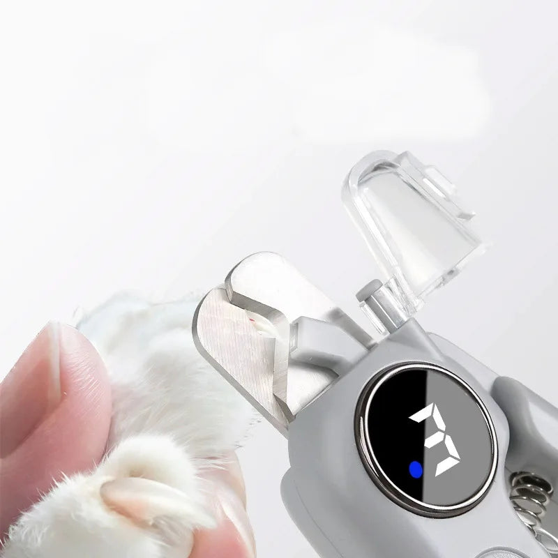 A hand holds a white pet's nail while a silver LED pet nail clipper and grinder is open.
