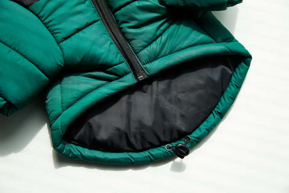 A dark green quilted winter coat with a black zipper and lining is shown flat.