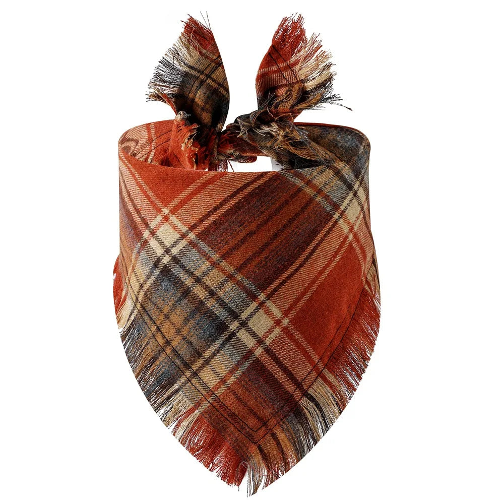 A plaid bandana in shades of rust, brown, and tan with fringed ties for a dog or cat.