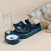Eine graue Katze isst aus einer blauen Futterschale mit Wasserabgießer.