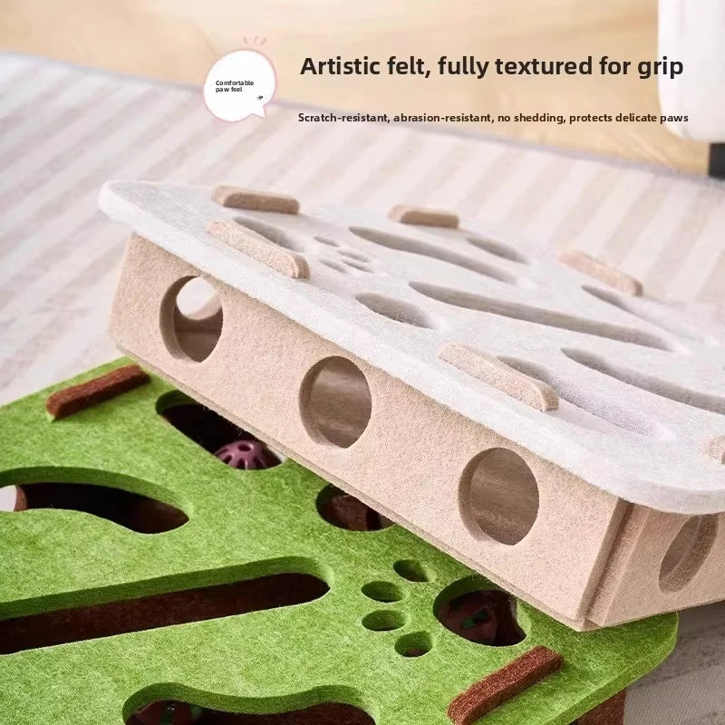 A felt puzzle toy for cats featuring textured grips and holes, placed on a green felt mat.