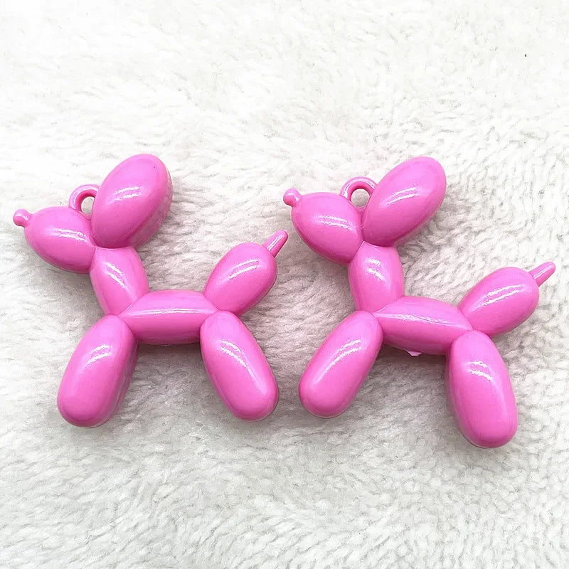 A pair of pink acrylic balloon dog charm pendants for jewelry making and keychains.
