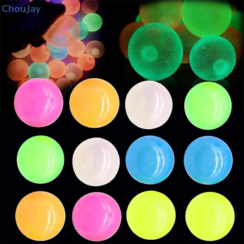 A collection of glow-in-the-dark sticky sensory balls in various colors including pink, yellow, green, and blue.