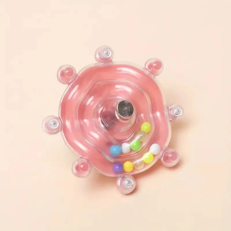 Pinker, runder interaktiver Leckerli-Dispenser mit zentraler Öffnung und bunten Leckereien drinnen.