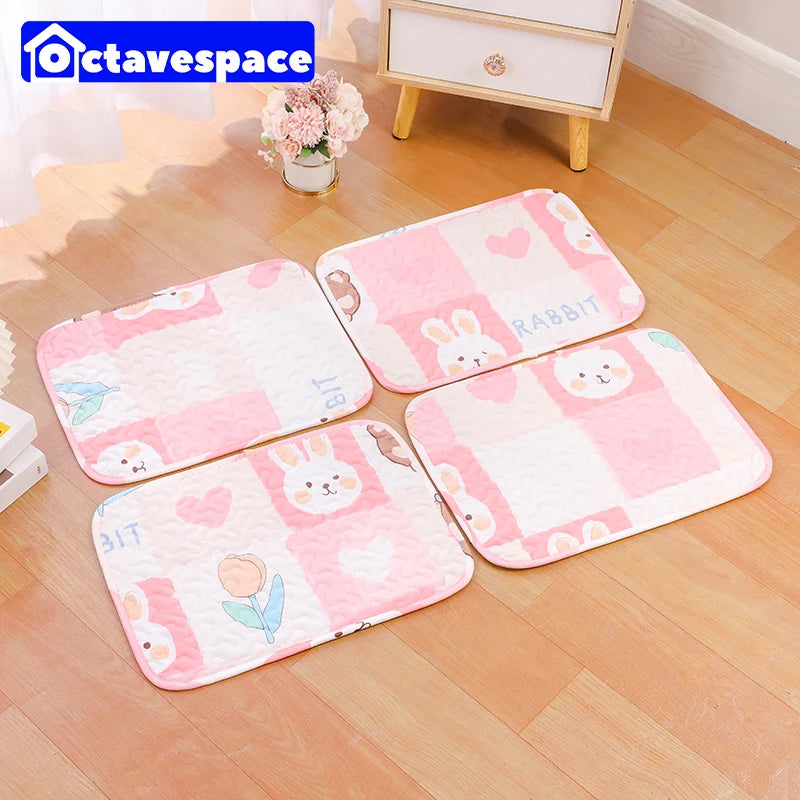 Pink and white checkered soft cotton pet cage mats with rabbit designs placed on a wooden floor.