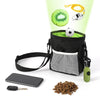 A black pet training treat bag filled with green treats, a black smartphone, and a small key are shown.
