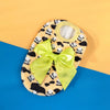 A yellow and black leopard print knit pet sweater for small dogs and cats, displayed on a light orange background.