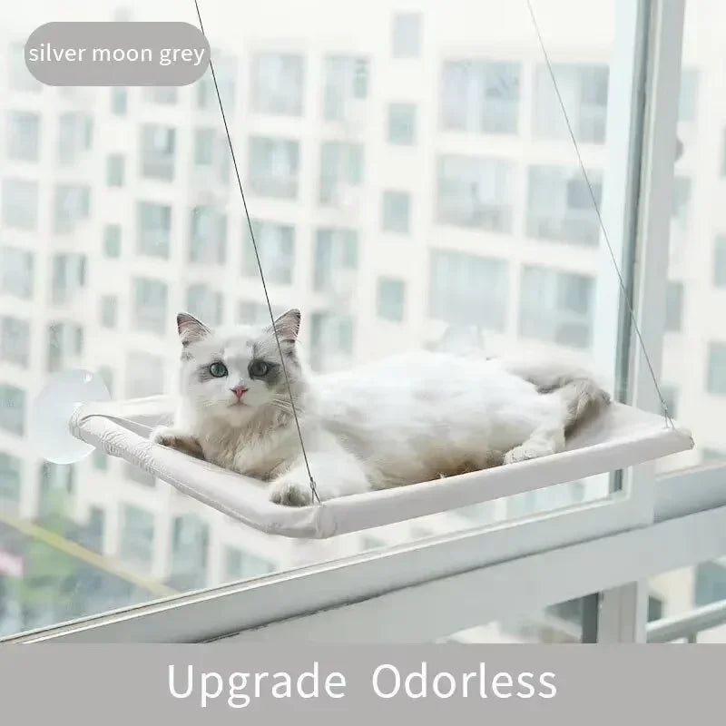 A white cat is relaxing in a silver moon grey cozy cat window hammock.